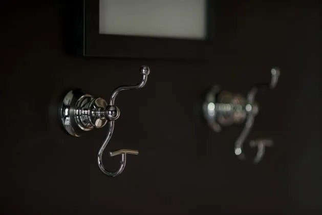 Silver bathroom towel hooks mounted on wall